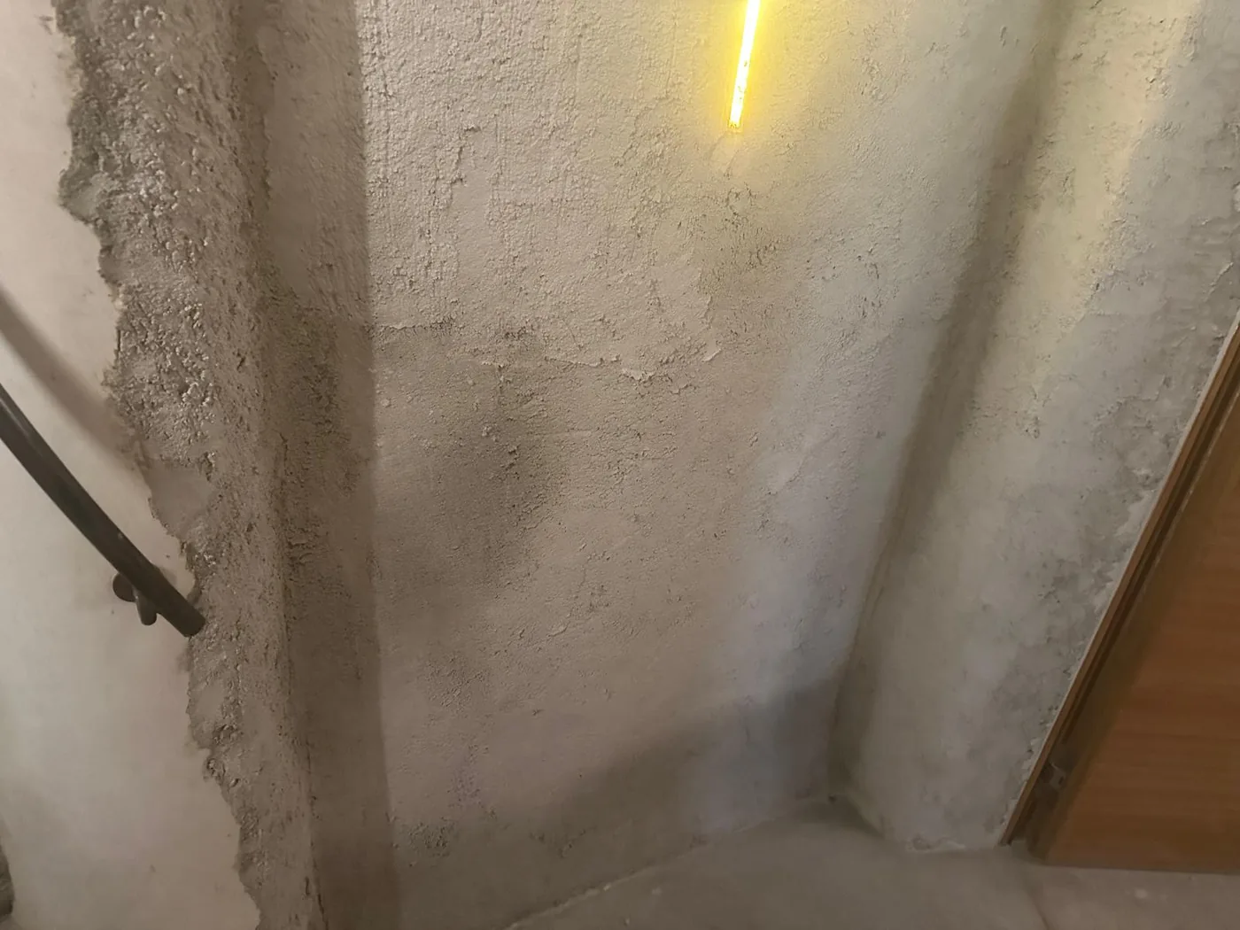 Mur en pierre intérieur remis à l'enduit ciment