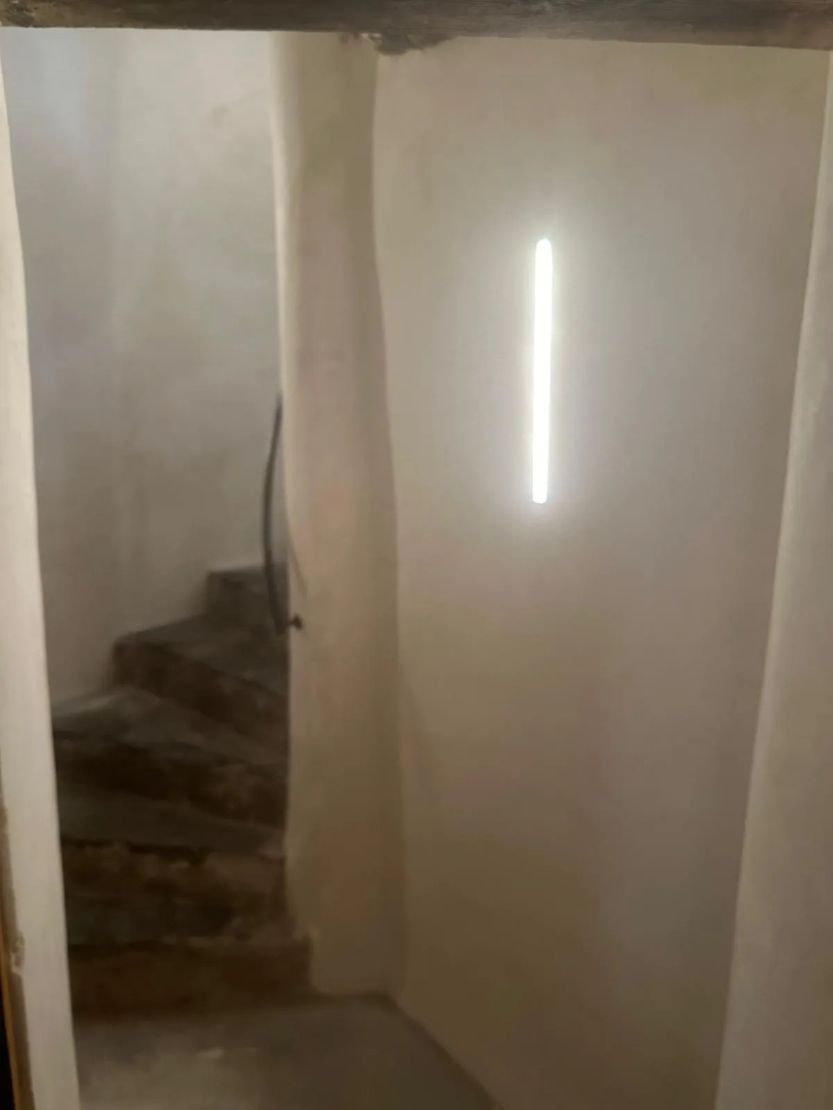 Cage d'escalier finie en enduit clair avec bandeau LED
